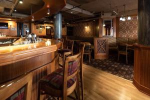 a bar in a restaurant with a counter and chairs at Scandic Kouvola in Kouvola