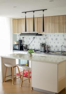 una cucina con un grande bancone bianco e sedie di Laurel Hill Suites a Nairobi
