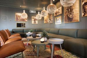 a waiting room with couches and tables and chandeliers at Scandic Vestfjord Lofoten in Svolvær