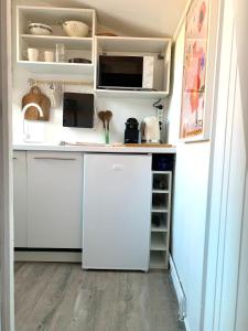 a kitchen with white cabinets and a white refrigerator at Studio in historical monument in city center in Montpellier