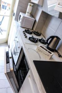 encimera de cocina con fogones y microondas en Domus Marconi Roma, en Roma