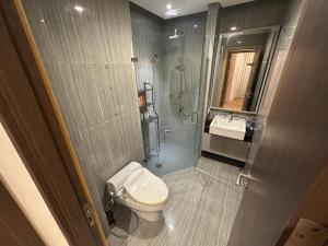 a bathroom with a toilet and a shower and a sink at Apartemen capitol suites in Jakarta +3 photos