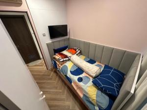 a small bed in a room with a television at Apartemen capitol suites in Jakarta