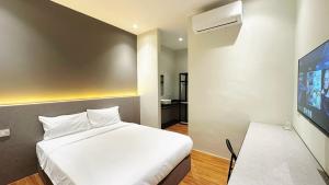 a bedroom with a white bed and a tv at Legend Inn Sungai Petani in Sungai Petani +19 photos