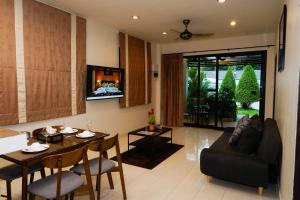 a living room with a table and a couch at Katanoi Resort in Kata Beach