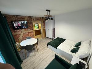 a bedroom with a bed and a table in a room at Noclegi u Kostka Sarbinowo in Sarbinowo