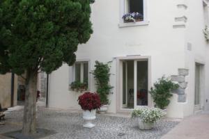 a white building with vases of flowers in front of it at Ca' Ottocento in Lazise