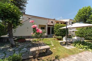 a house with a garden with a bench and pink flowers at Hotel Casa Lupi in Marciana Marina