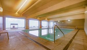ein Schwimmbad in einem Gebäude mit einem großen Fenster in der Unterkunft Studio-M in Middelkerke