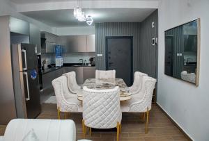 ein Esszimmer mit einem Tisch und Stühlen sowie eine Küche in der Unterkunft Urban Rest Homes in Mombasa + 6 Fotos