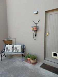 a bench sitting next to a door with a bike on the wall at 120 steps to the beach in Pringle Bay