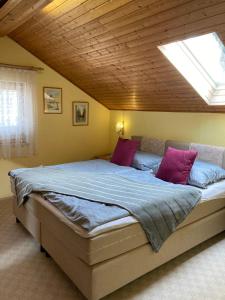 a bedroom with a large bed with purple pillows at Ferienwohnung Erika in Marquartstein