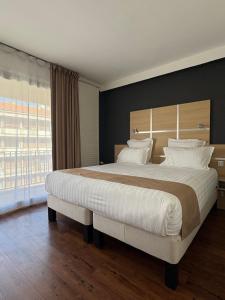 Postel nebo postele na pokoji v ubytování Cit'hôtel Le Chris'tel hôtel et restaurant