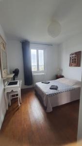 a bedroom with a bed and a desk and a window at House with garden and view of Rouen in Rouen +20 photos
