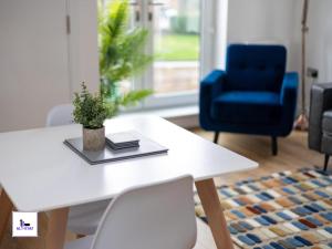a white table with a potted plant and a blue chair at Copper Beech by Alt-Stay - 2 Bed En Suite Contractor, Corporate & Relocation Accommodation near LBA with EV Plug, Parking, King Bed, Workspace, Kitchen, Smart TV and Wi Fi - Long Stay Ready with Weekly and Monthly Rates in Horsforth