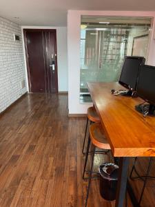 an office with a wooden desk with two monitors on it at April Fair Duplex Apartment Guagnzhou South Railway Station Min Jie Branch in Guangzhou