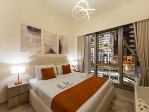 a bedroom with a large bed with a large window at EMAAR GRANDE 1BR Downtown I Steps to Fountain & Dubai Mall in Dubai +47 photos