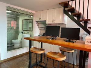 a home office with a desk with two computer monitors on it at April Fair Duplex Apartment Guagnzhou South Railway Station Min Jie Branch in Guangzhou