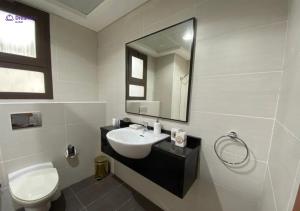 a bathroom with a sink and a toilet and a mirror at Dream Inn Apartments - Luxury 2 BR Mina Al Fajer - Harbor View - Al Fujairah in Rūl Ḑadnā +18 photos