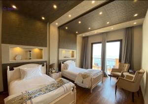 a hotel room with two beds and a chair at Dream Inn Apartments - Luxury 2 BR Mina Al Fajer - Harbor View - Al Fujairah in Rūl Ḑadnā