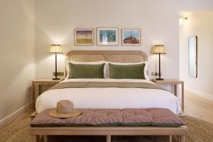 een slaapkamer met een groot bed met een hoed erop bij Spier Hotel and Wine Farm in Stellenbosch
