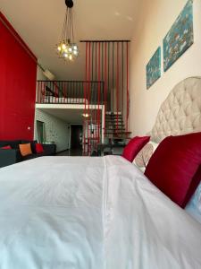 a bedroom with a large white bed and a living room at April Fair Duplex Apartment Guagnzhou South Railway Station Min Jie Branch in Guangzhou