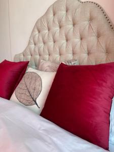 a bedroom with a bed with red pillows and a headboard at April Fair Duplex Apartment Guagnzhou South Railway Station Min Jie Branch in Guangzhou