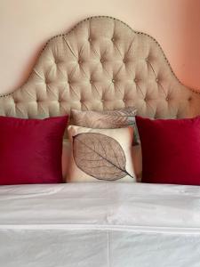 a bed with red pillows and a large headboard at April Fair Duplex Apartment Guagnzhou South Railway Station Min Jie Branch in Guangzhou