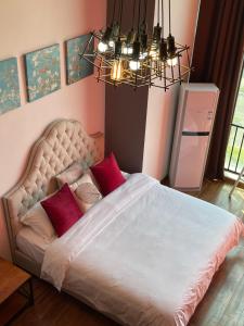a bedroom with a white bed with red pillows at April Fair Duplex Apartment Guagnzhou South Railway Station Min Jie Branch in Guangzhou