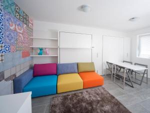 a colorful couch in a room with a table at Stay COOPER l Guesthouse 37 in Bolzano