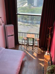 a room with a table and chairs and a window at April Fair Duplex Apartment Guagnzhou South Railway Station Min Jie Branch in Guangzhou