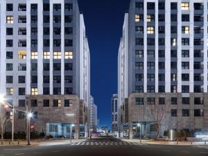 two tall buildings in a city at night at Le Collective Sokcho Central in Sokcho