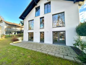 a white house with large windows and a driveway at Perfekt für 2! Küche Netflix BBQ Flughafen München in Kranzberg