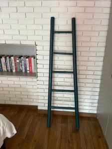 a black ladder against a brick wall with books at April Fair Duplex Apartment Guagnzhou South Railway Station Min Jie Branch in Guangzhou