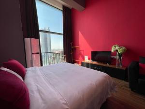 a red bedroom with a white bed and a tv at April Fair Duplex Apartment Guagnzhou South Railway Station Min Jie Branch in Guangzhou