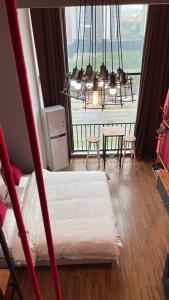 a room with a bed and a large window at April Fair Duplex Apartment Guagnzhou South Railway Station Min Jie Branch in Guangzhou