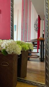 two vases with flowers in front of a mirror at April Fair Duplex Apartment Guagnzhou South Railway Station Min Jie Branch in Guangzhou