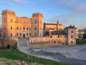 a large brick building with two towers on a street at Al fiume in Mesola