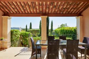 eine Terrasse mit Tisch und Stühlen auf einem Deck in der Unterkunft Saint-Tropez Golf Residences in Saint-Tropez