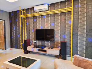 a living room with a flat screen tv on a wall at Kempas -- 32 Pax SemiD, Near Paradigm Mall JB in Johor Bahru