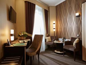 um quarto de hotel com uma secretária, cadeiras e uma janela em Birch Yard Hotel em Rostov on Don