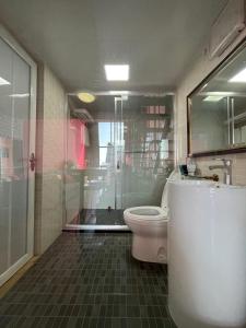 a bathroom with a glass shower and a toilet at April Fair Duplex Apartment Guagnzhou South Railway Station Min Jie Branch in Guangzhou