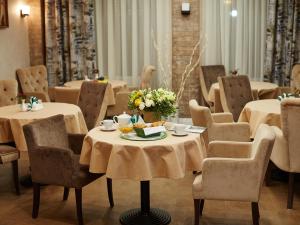 uma sala de jantar com mesas e cadeiras com flores em Birch Yard Hotel em Rostov on Don