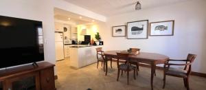 a living room with a dining room table and a kitchen at Sandstone Suites - In the heart of Port Fairy in Port Fairy