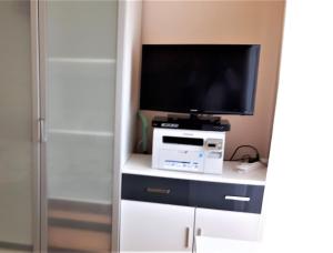 a room with a tv and a computer on a desk at Ferienwohnung Laura in Langenargen