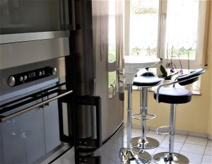 a kitchen with a stove and two bar stools at Ferienwohnung Laura in Langenargen