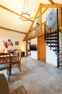 a living room with a spiral staircase and a table at West Hollowcombe Farm Cottages - full site booking in Dulverton