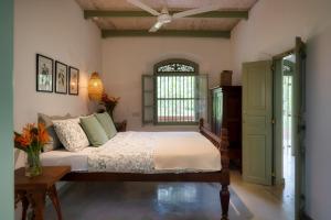 a bedroom with a bed and a ceiling fan at Sukomala Imaduwa in Ahangama