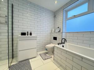 a white bathroom with a tub and a toilet at Modern 2 Bedroom Apartment - Near Hospital & Racecourse in Doncaster +14 photos