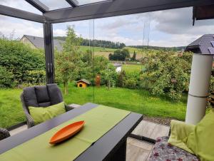 a table with an orange plate on it in front of a window at Ferienhaus Diemelsee-Sudeck in Diemelsee